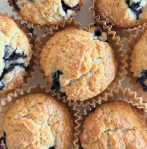 reshly baked blueberry muffins with golden tops, soft and fluffy, made without eggs or nuts.